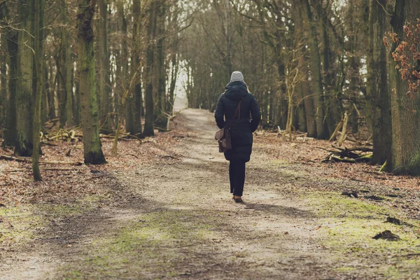 Vrouw wandelen langs een bos track — Stockfoto