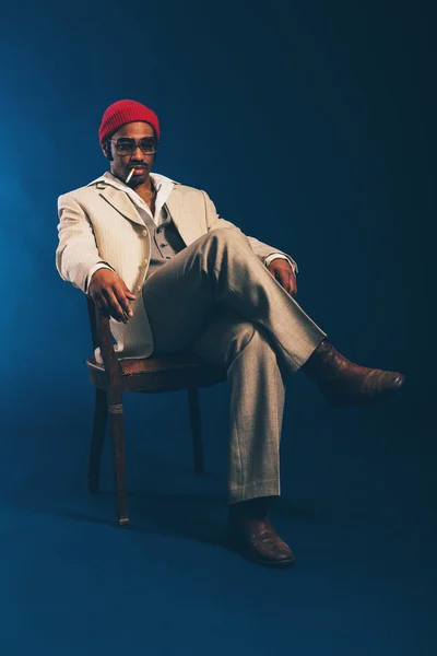 Homem de negócios elegante sentado fumando em uma cadeira — Fotografia de Stock