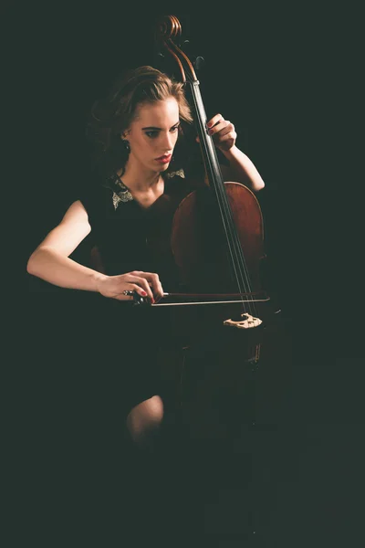 Девушка, играющая ночью на виолончели — стоковое фото