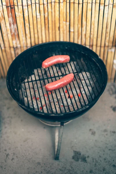 Two beef sausages on an outdoor grill — Stock Photo, Image