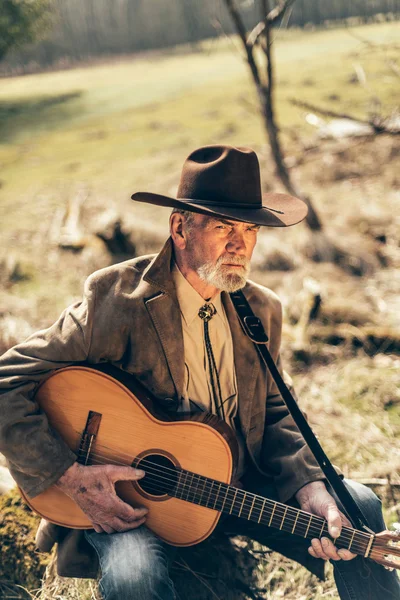 Senior gitarist ontspannen met zijn gitaar — Stockfoto