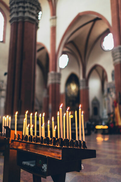 burning votive tapers in a church interior