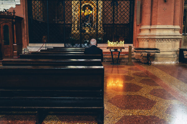 Elderly man worshipping at an altar
