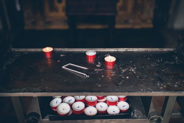 Brandende rode kaarsen in een kerk interieur — Stockfoto