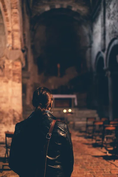 Donna in piedi nel buio interno di una chiesa — Foto Stock