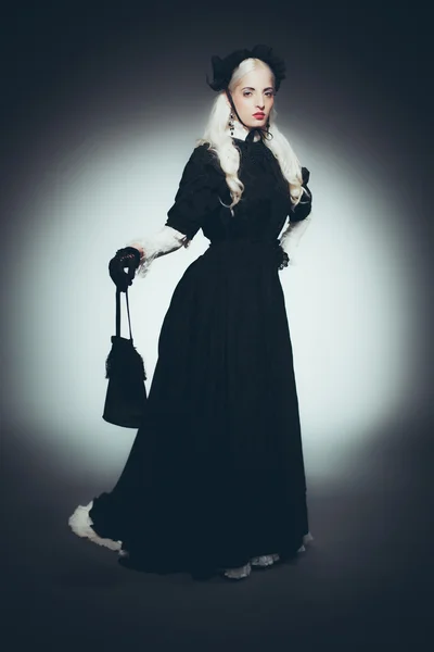 Женщина с сумкой в черном платье — стоковое фото