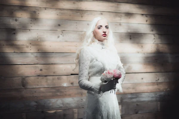 Femme avec des fleurs en robe blanche — Photo