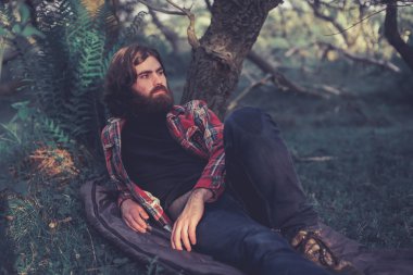 Backpacker relaxing under a tree