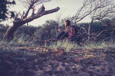 Man Leaning Against Fallen Tree