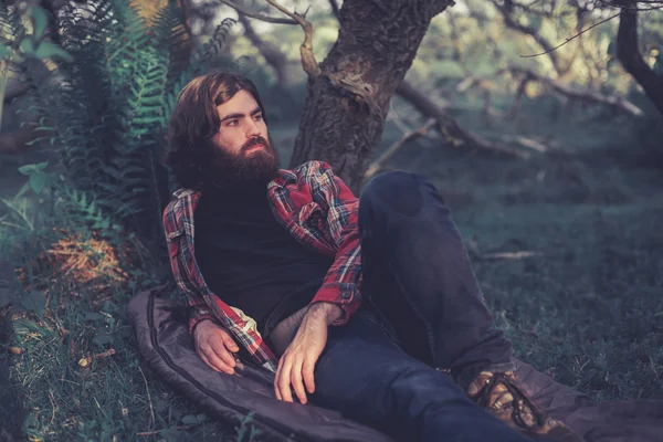 Backpacker relaxing under a tree — Stockfoto