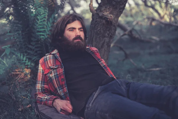 Backpacker relaxing under a tree — Stockfoto