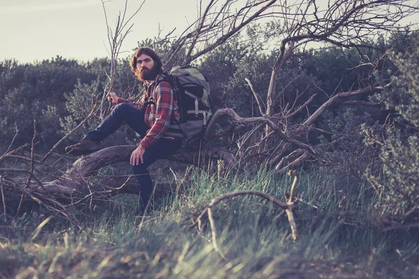 Man with Backpack Sitting on Fallen Tree — Stock fotografie