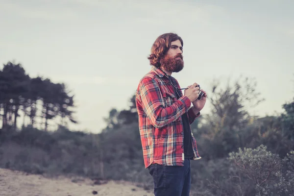 Backpacker with a camera in the wilderness — Stock Photo, Image