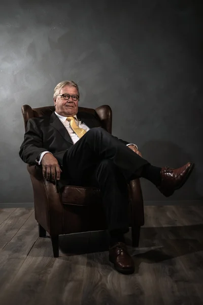 Successful senior man relaxing in an armchair — Stock Photo, Image