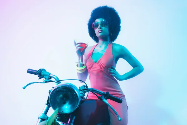 Элегантная леди с коктейлем на мотоцикле — стоковое фото