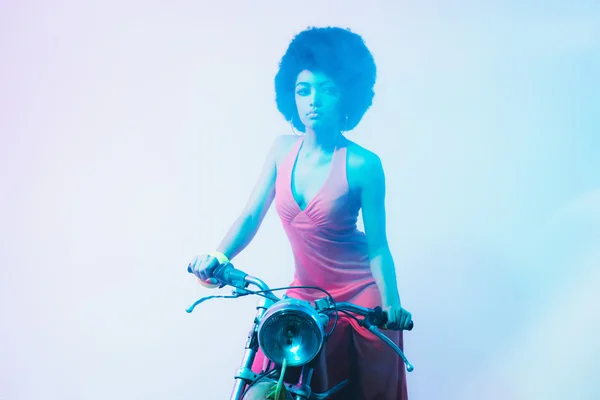 Mulher elegante em uma motocicleta em um estúdio Fuzzy — Fotografia de Stock