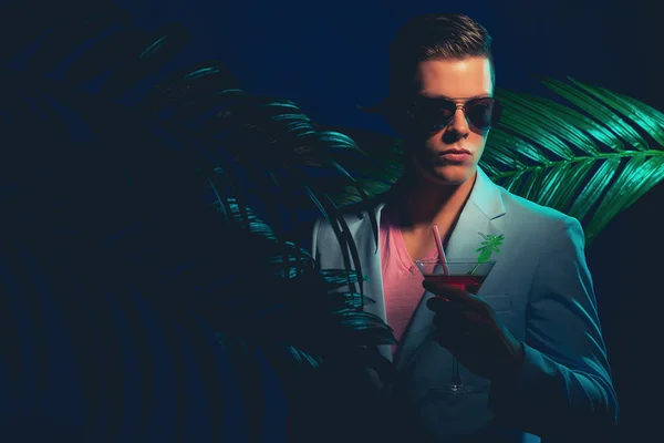 Elegante ragazzo con sfumature che tiene cocktail — Foto Stock