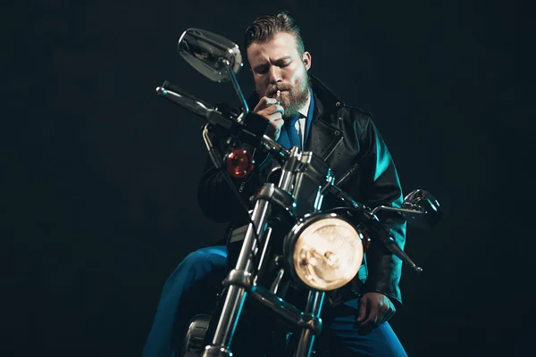 Stylish man on a bike lighting up a cigarette — 스톡 사진