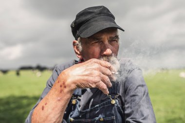 Elderly grizzled farmer enjoying  smoke