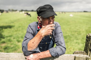 Senior farmhand taking smoke break