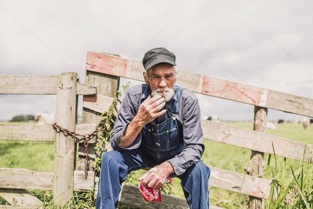 Elderly farm worker sitting and smoking