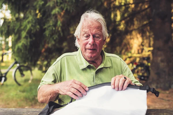 Garvade äldre Man sitter i skogen — Stockfoto