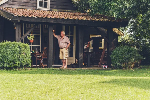 Pensionerad man som stod under verandan — Stockfoto