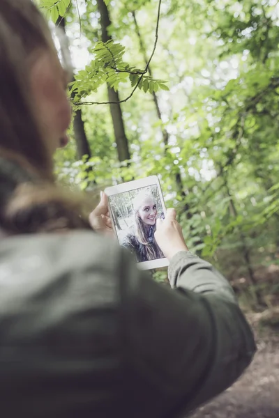 Mulher na floresta fazendo selfie — Fotografia de Stock