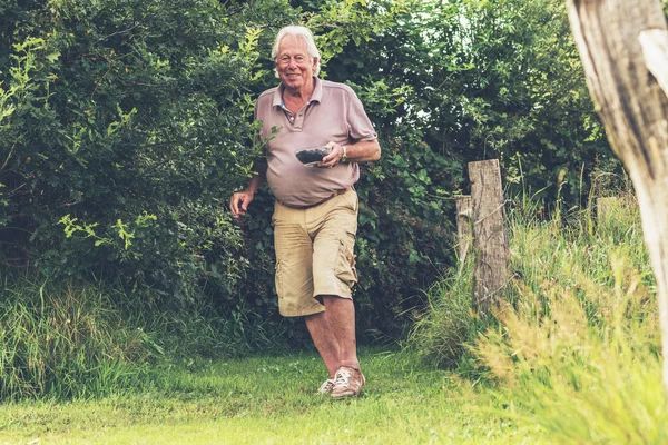 Senior man lopen in tuin — Stockfoto