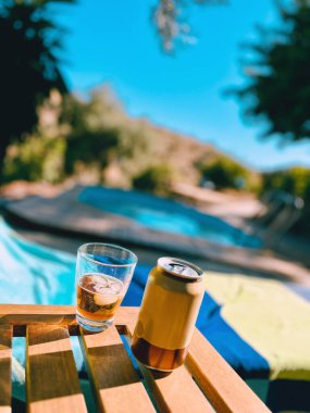 Bir bilardo masasının yanında bir bardak birayla.