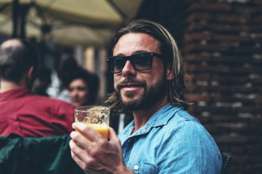 Taze meyve suyu içme gözlüklü adam