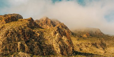 Alçak irtifa bulutlarında dağların sert kayalık yamaçları. Nijar, Almerya, Endülüs, İspanya.
