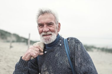 Sahilde gülümseyen kıdemli beachcomber.