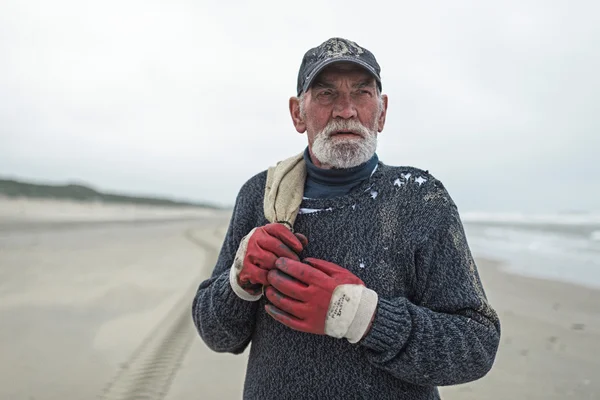 Senior beachcomber with work gloves — Stock Photo, Image