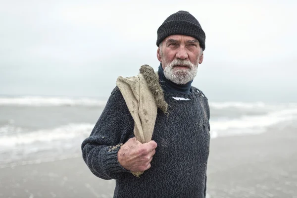 Beachcomber sênior com saco de serapilheira — Fotografia de Stock