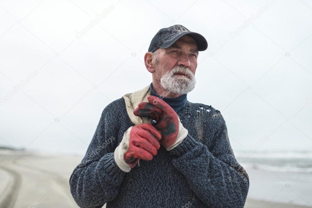 Senior beachcomber with work gloves