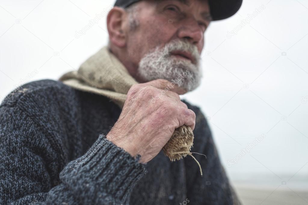 Hand of beachcomber holding burlap sack