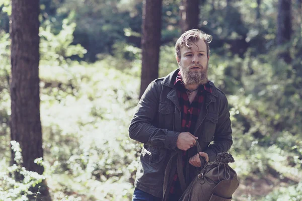 Backpacker met baard wandelen in het bos. — Stockfoto