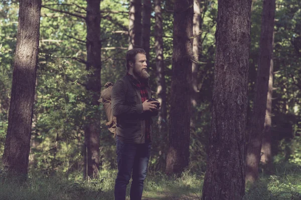 Homem segurando câmera vintage na floresta . — Fotografia de Stock