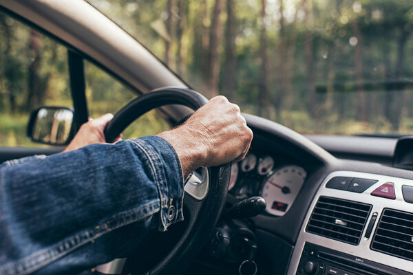 Hands on steering wheel of car