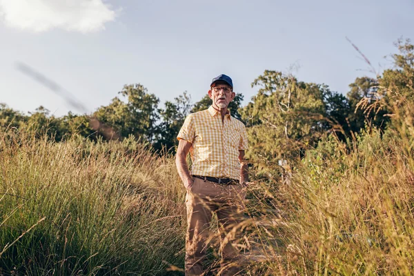 Man die tussen hoog gras in park. — Stockfoto