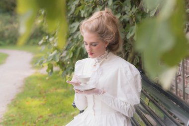 Posh victorian woman having cup