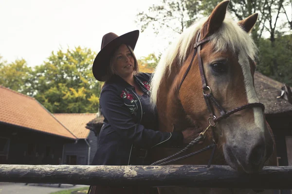 Cowgirl embrace horse 's neck . — стоковое фото