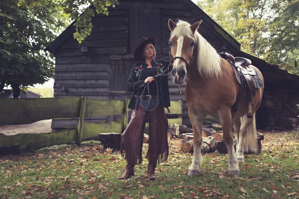 Cowgirl steht mit Pferd — Stockfoto
