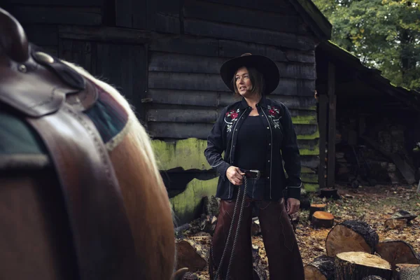 Cowgirl permanent met paard — Stockfoto