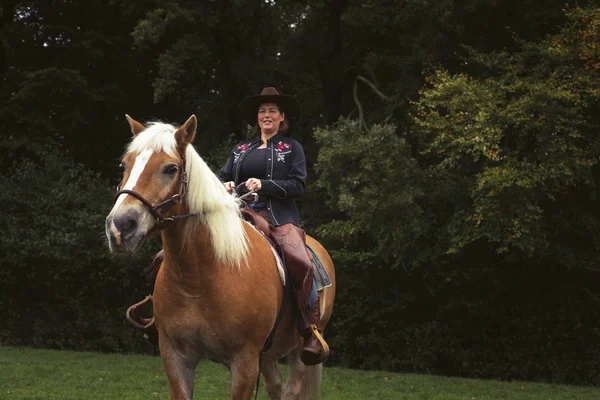 Leende kvinna med hatt häst — Stockfoto