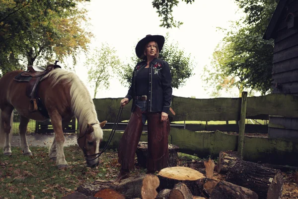Cowgirl steht mit Pferd . — Stockfoto