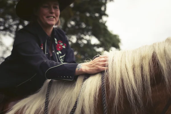 Main de femme caressant des crinières de cheval — Photo
