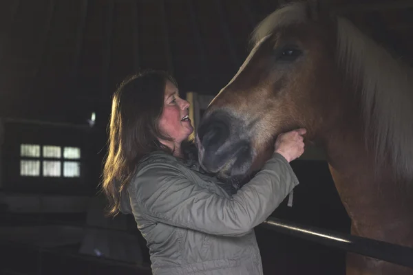 Gelukkige vrouw knuffelen haar paard — Stockfoto