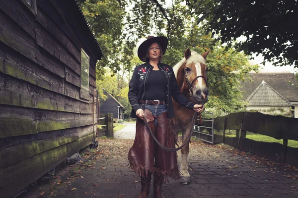 Kvinna går med häst — Stockfoto